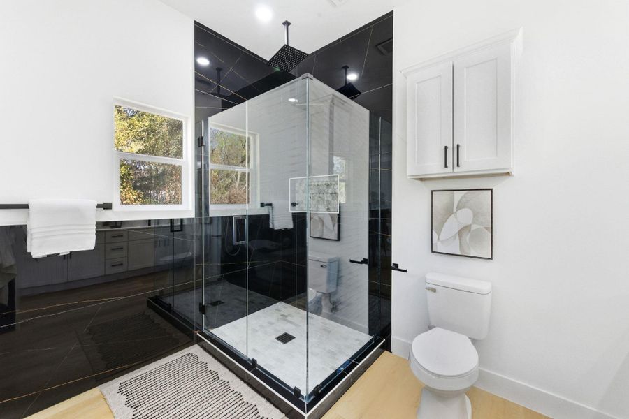 Bathroom featuring a shower stall and wood finished floors Bathroom featuring a shower stall and wood finished floors