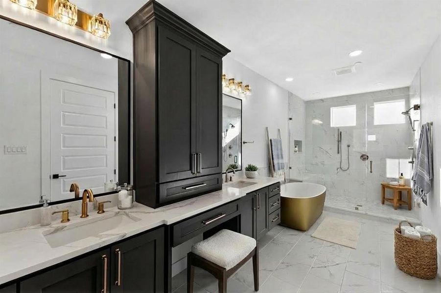 Full bathroom with double vanity, a marble finish shower, a freestanding tub, light marble finish flooring, and recessed lighting