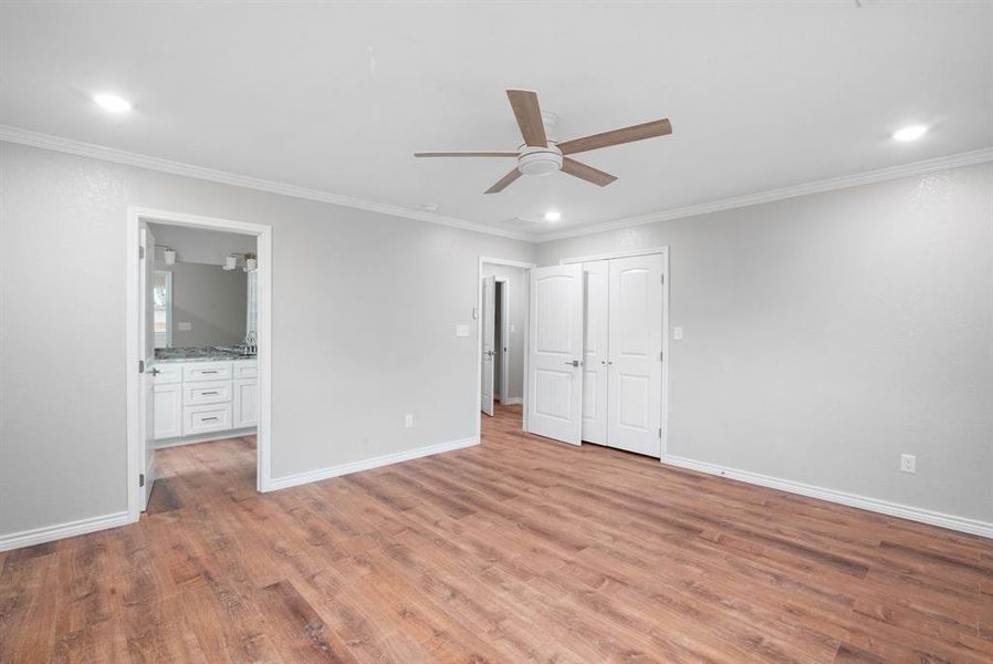 Unfurnished bedroom with ceiling fan, light wood-type flooring, and ornamental molding Unfurnished bedroom with ceiling fan, light wood-type flooring, and ornamental molding