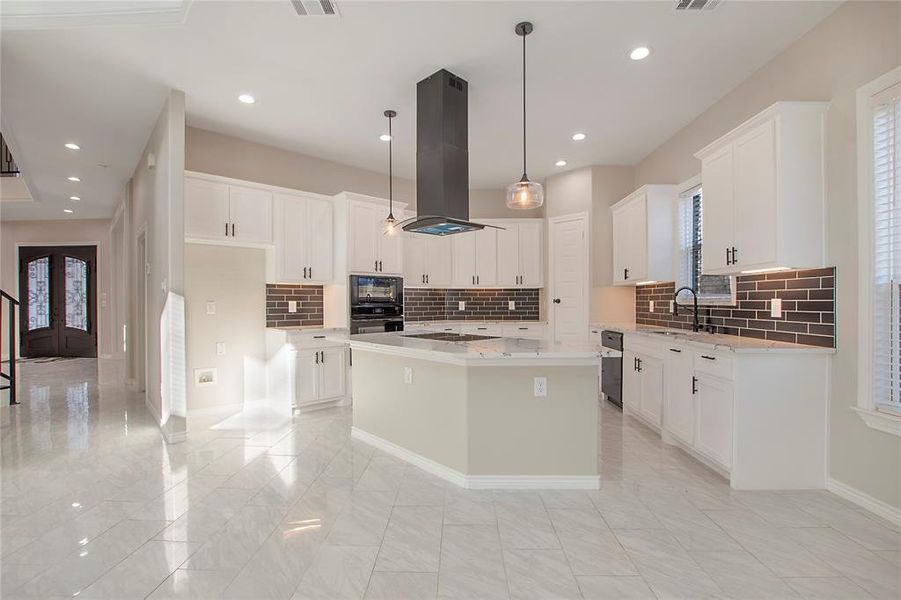 Kitchen featuring white cabinetry, hanging light fixtures, a center island, and island exhaust hood