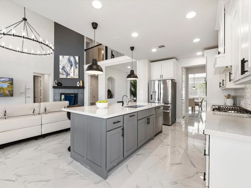 Open concept is the way to go! Whip up a snack or a gourmet meal, all while interacting with guests, family and friends! Modern/industrial pendent lights over the kitchen island.