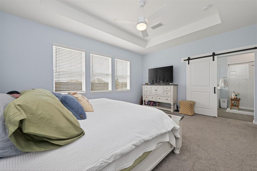 Primary bedroom offering a spacious layout, abundant natural light and a luxurious ensuite
