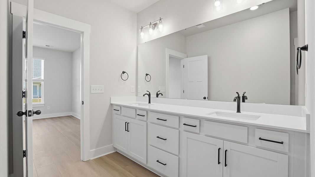 Accomplished design shines in this primary bath with dual vanity and a sleek walk-in shower at Village at Midway Accomplished design shines in this primary bath with dual vanity and a sleek walk-in shower at Village at Midway