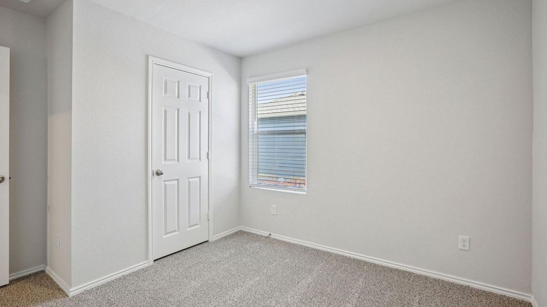 Unfurnished bedroom with light carpet and a closet