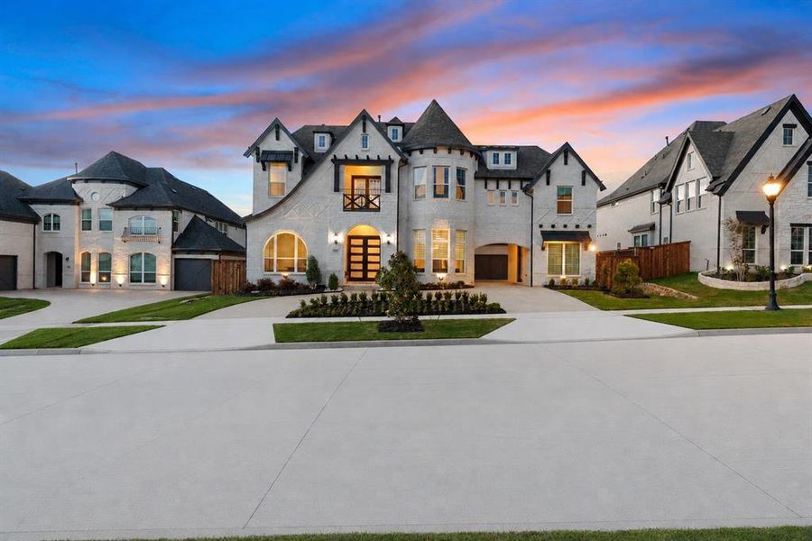 White brick exterior featuring a prominent turret, dark trim accents, multiple gables, and a contemporary glass panel entry door White brick exterior featuring a prominent turret, dark trim accents, multiple gables, and a contemporary glass panel entry door