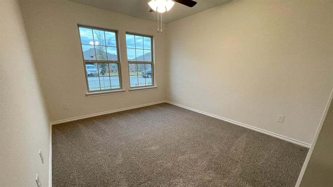 Carpeted room with neutral wall tones and white baseboards