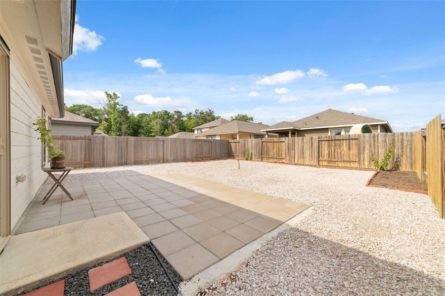 Private backyard with an extended patio and open space, perfect for outdoor seating and entertaining.