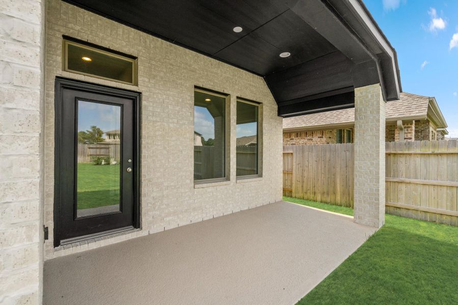 Covered rear patio with recessed lighting provides shaded outdoor living space.