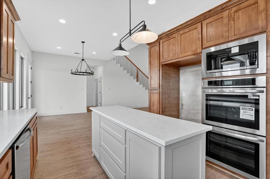 Kitchen island featuring a light-toned countertop and paneled cabinetry