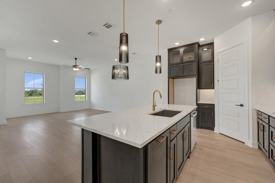 Open-concept kitchen and living area featuring light wood-finish flooring Open-concept kitchen and living area featuring light wood-finish flooring