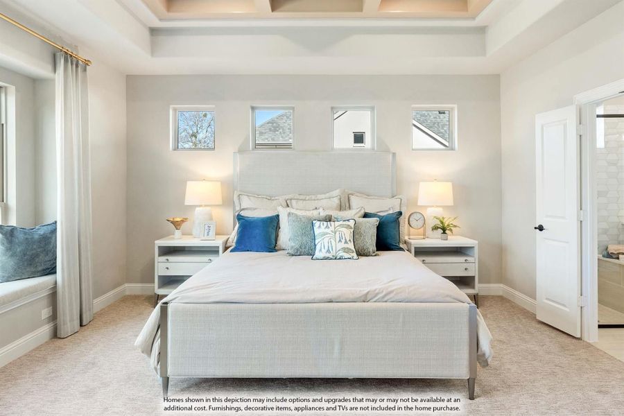 Master bedroom with coffered ceiling, upholstered bed, blue accent pillows, and ensuite bathroom door visible Master bedroom with coffered ceiling, upholstered bed, blue accent pillows, and ensuite bathroom door visible