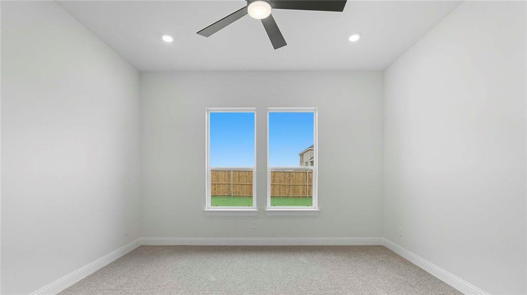Bedroom with neutral carpeting, two large windows, a ceiling fan, and recessed lighting