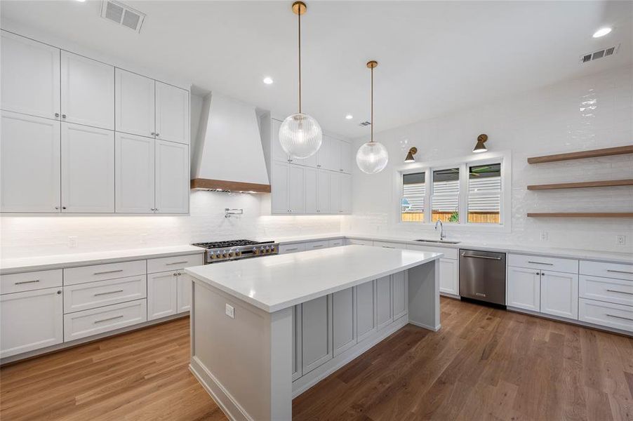 Beautiful chef's kitchen with 48' range and 48" built in fridge and windows overlooking backyard