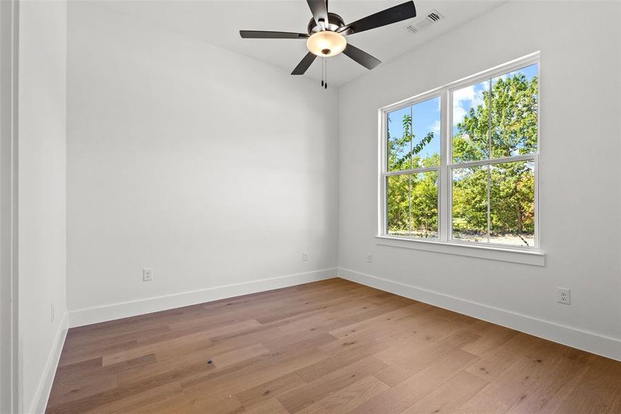 Spare room featuring light wood-type flooring and a ceiling fan Spare room featuring light wood-type flooring and a ceiling fan