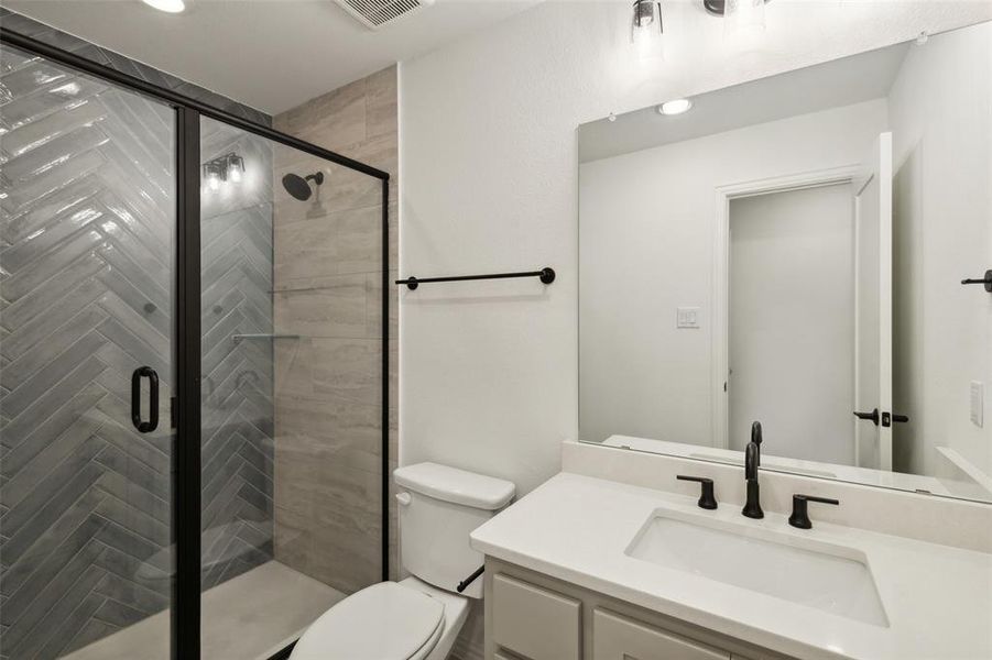 Bathroom with vanity, toilet, and walk in shower