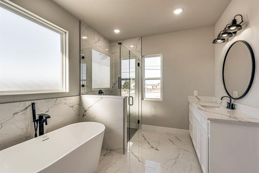 Full bath with a wealth of natural light, a marble finish shower, marble finish floor, and a freestanding tub