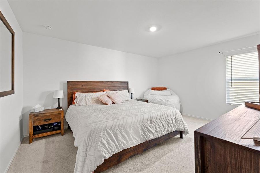 Bedroom featuring light colored carpet and baseboards