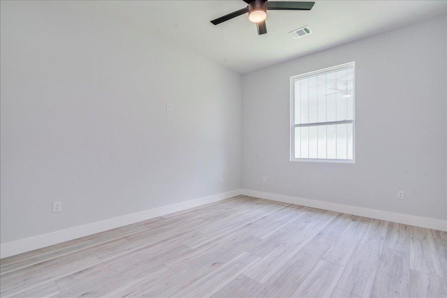 Additional room with a ceiling fan and light wood-style flooring