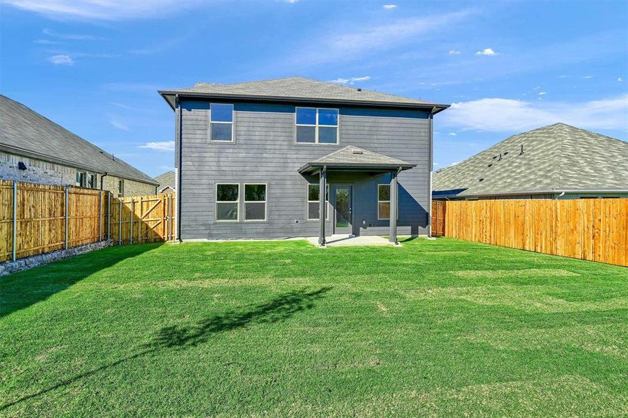 Rear view of house featuring a lawn and a patio area