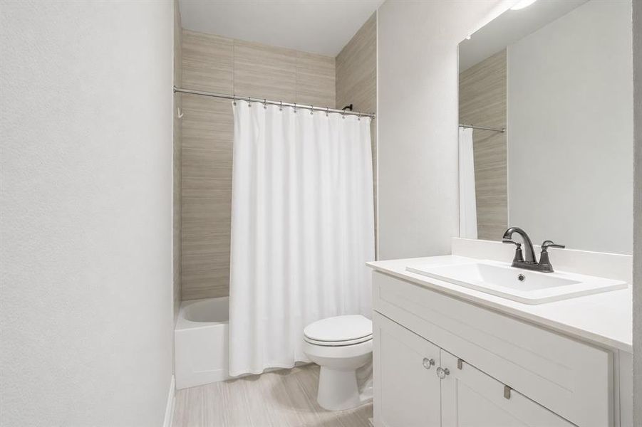 Bathroom featuring a white vanity with a rectangular sink, a matte black faucet, and a large wall-mounted mirror Bathroom featuring a white vanity with a rectangular sink, a matte black faucet, and a large wall-mounted mirror