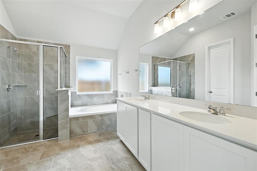 Full bathroom with vaulted ceiling, a stall shower, double vanity, and a bath Full bathroom with vaulted ceiling, a stall shower, double vanity, and a bath