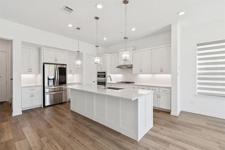 Kitchen featuring appliances with stainless steel finishes, decorative backsplash, hanging light fixtures, white cabinetry, and recessed lighting Kitchen featuring appliances with stainless steel finishes, decorative backsplash, hanging light fixtures, white cabinetry, and recessed lighting
