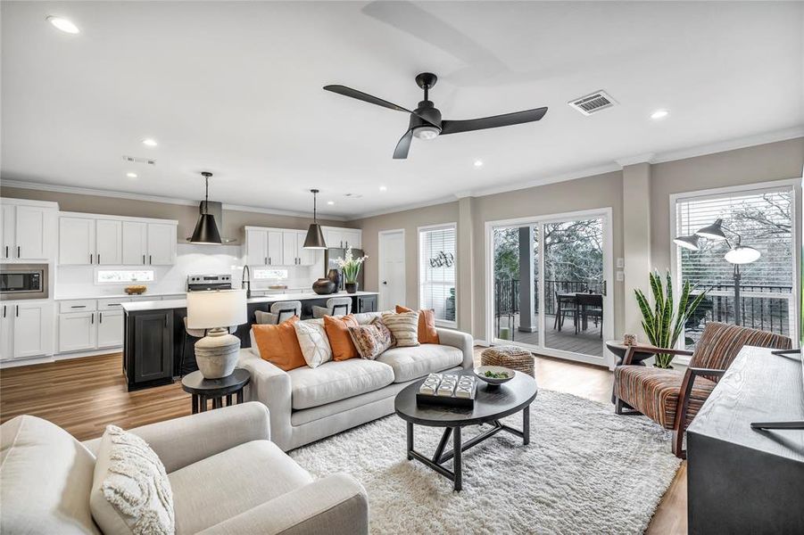 Living room with crown molding, light wood-type flooring, recessed lighting, and a ceiling fan