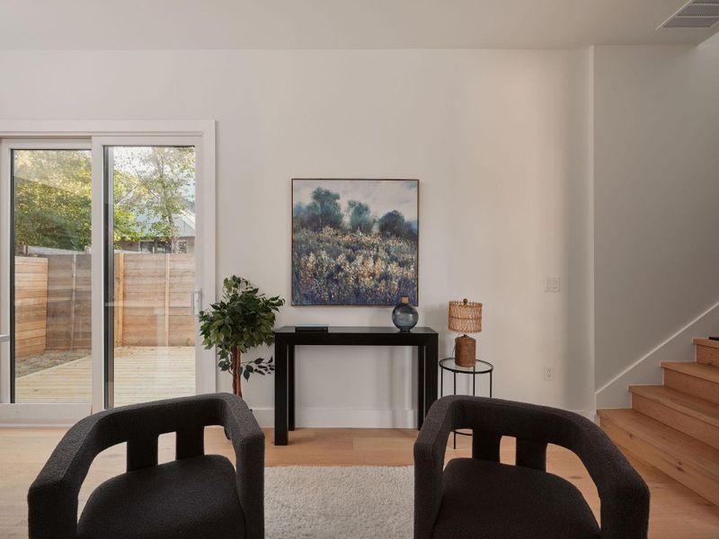 Sitting room with wood finished floors and stairway Sitting room with wood finished floors and stairway