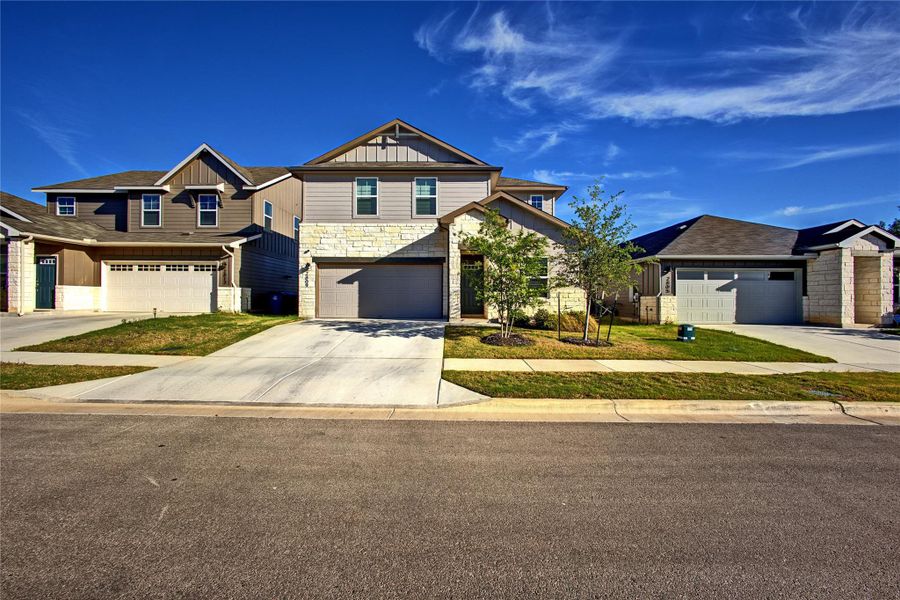 Craftsman-style house featuring stone siding, driveway, an attached garage, and board and batten siding Craftsman-style house featuring stone siding, driveway, an attached garage, and board and batten siding