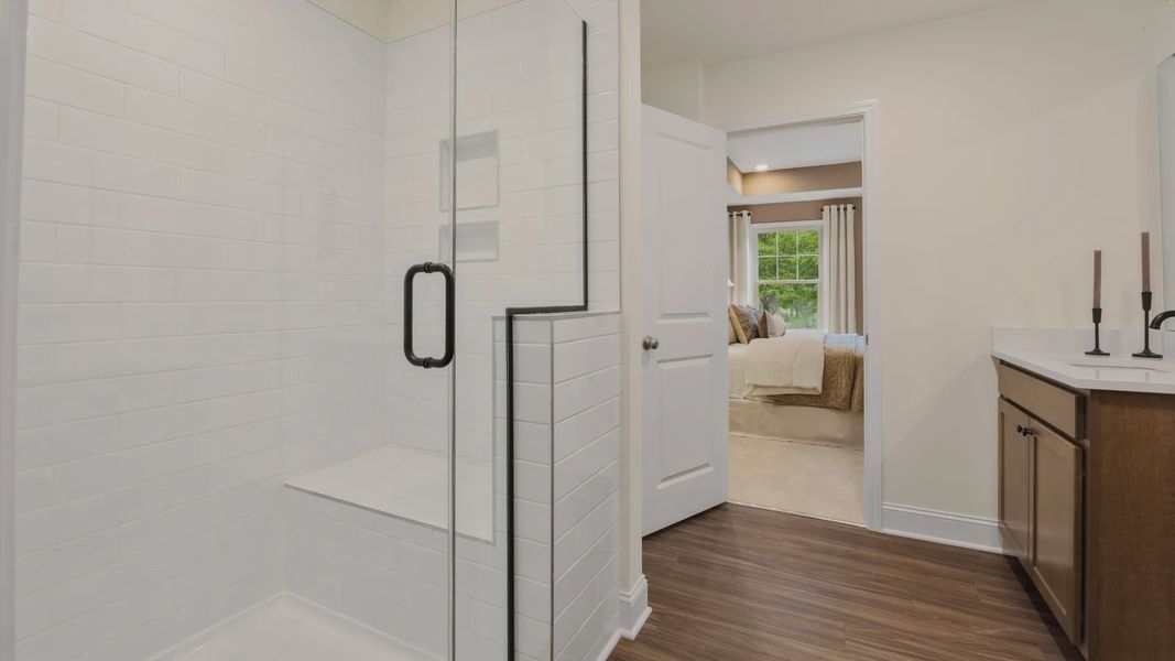 Townsend home plan en suite bathroom with separate vanities, tile shower, and ample closet storage