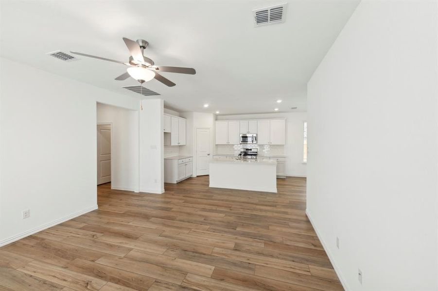 Unfurnished living room with ceiling fan and hardwood / wood-style flooring