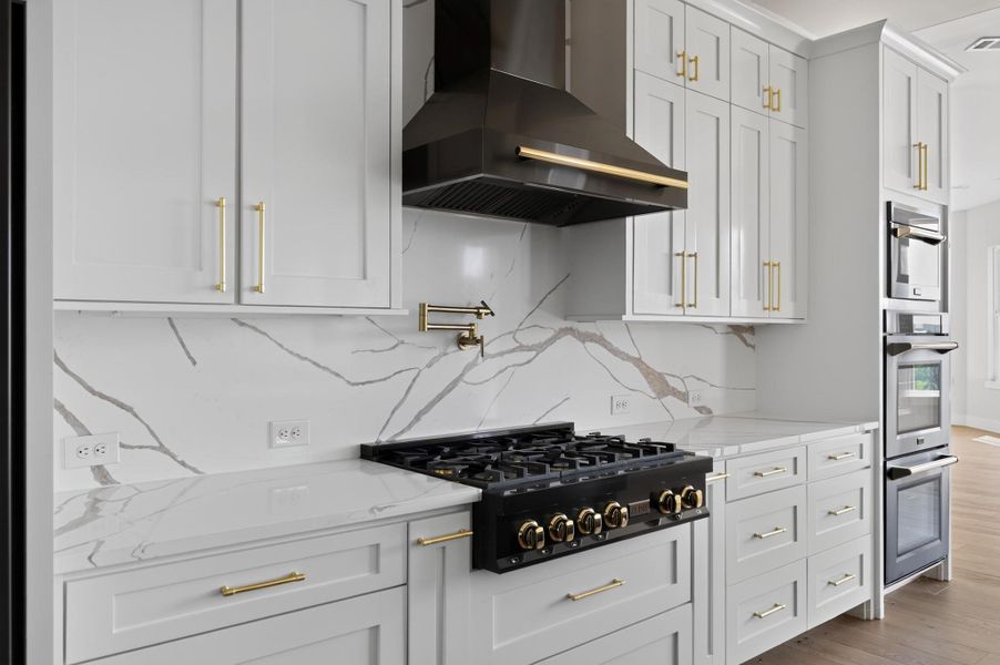 Elegant quartz backsplashes and professional-grade appliances define this chef's kitchen workspace.