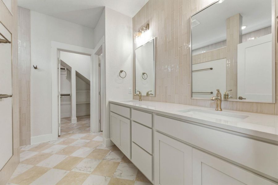 Primary vanity with great storage and lighting.  Separate toilet room just before the closet entrance.