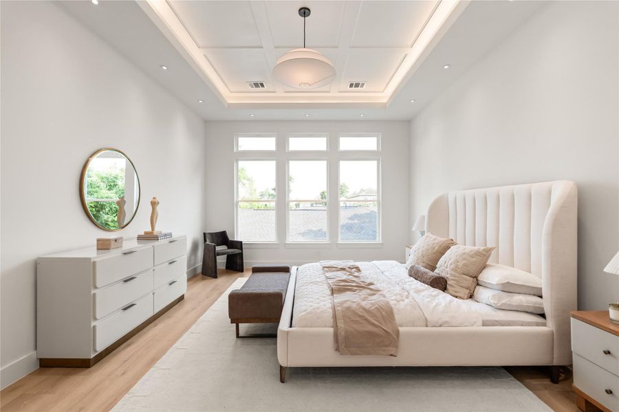 Tall coffered ceilings and a wall of windows give this primary suite a sense of scale that's hard to find in most new construction. There's room here to breathe, and light that makes the whole day feel a little brighter.