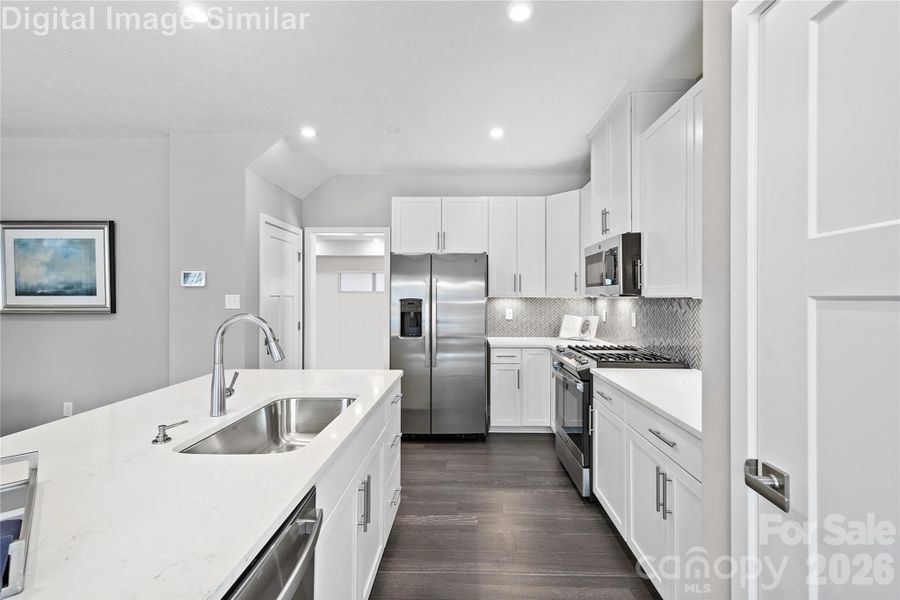 Elegant open-concept kitchen with upscale finishes, tall cabinetry, gleaming countertops and appliances - designed to impress and built to inspire Elegant open-concept kitchen with upscale finishes, tall cabinetry, gleaming countertops and appliances - designed to impress and built to inspire