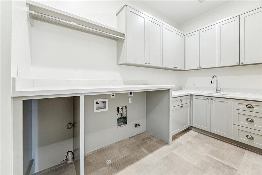 A dream laundry room with custom cabinetry, a spacious folding station, hanging racks, and ample storage for laundry essentials, all designed for maximum organization and efficiency. Photo as of 11/5//2024