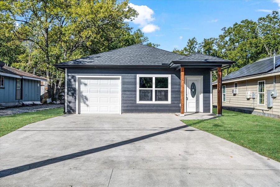 View of front of property with a garage and a front lawn