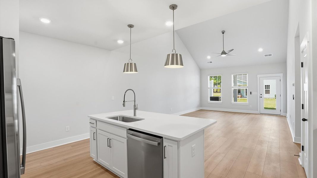 Exceptional kitchen featuring a spacious island, eye-catching pendant lights, and modern finishes at Village at Midway Exceptional kitchen featuring a spacious island, eye-catching pendant lights, and modern finishes at Village at Midway