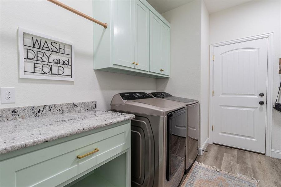 Laundry room featuring light hardwood / wood-style floors, cabinets, and independent washer and dryer