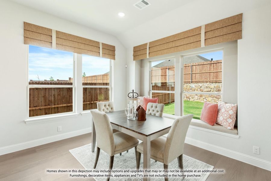 Breakfast nook with dining table, built-in window seat, and roman shades overlooking a fenced backyard Breakfast nook with dining table, built-in window seat, and roman shades overlooking a fenced backyard