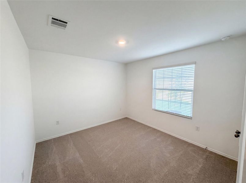 Unfurnished room featuring dark carpet and baseboards