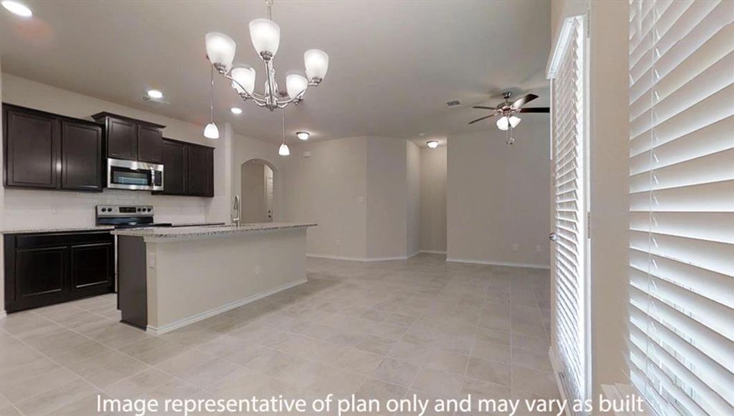 Kitchen featuring pendant lighting, appliances with stainless steel finishes, light stone counters, a center island with sink, and arched walkways Kitchen featuring pendant lighting, appliances with stainless steel finishes, light stone counters, a center island with sink, and arched walkways