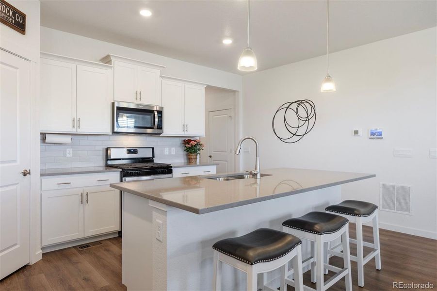 Modern finishes, pendant lighting, and Whirlpool appliances bring together style and function.