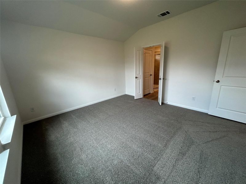 Unfurnished bedroom featuring vaulted ceiling and carpet floors Unfurnished bedroom featuring vaulted ceiling and carpet floors
