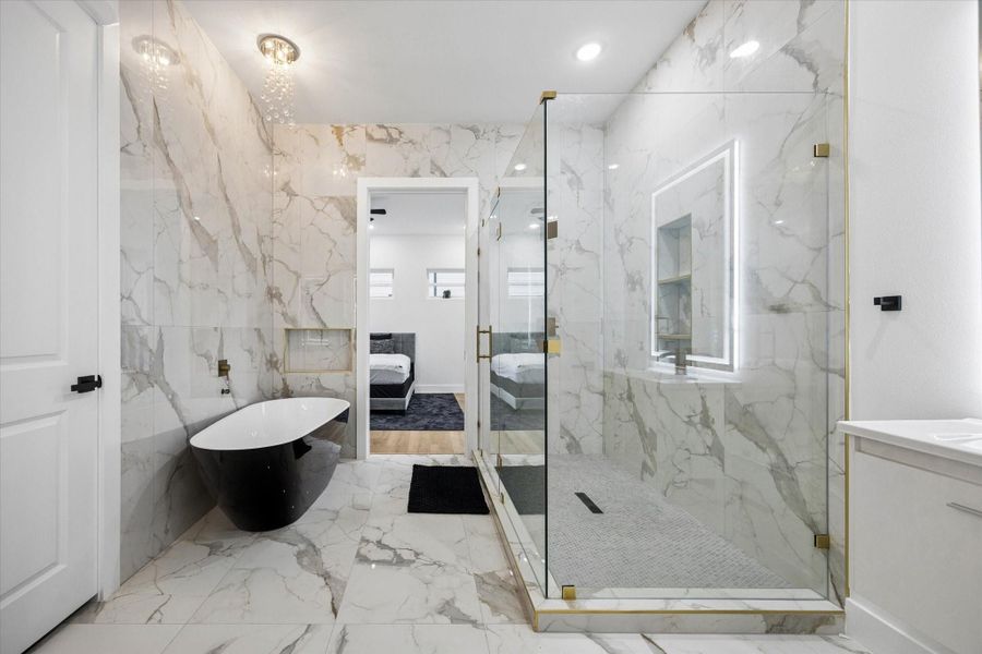 This luxurious bathroom features elegant marble walls and flooring, a sleek freestanding tub, and a spacious glass-enclosed shower. Modern lighting and gold accents add a touch of sophistication, creating a serene and stylish retreat. This luxurious bathroom features elegant marble walls and flooring, a sleek freestanding tub, and a spacious glass-enclosed shower. Modern lighting and gold accents add a touch of sophistication, creating a serene and stylish retreat.