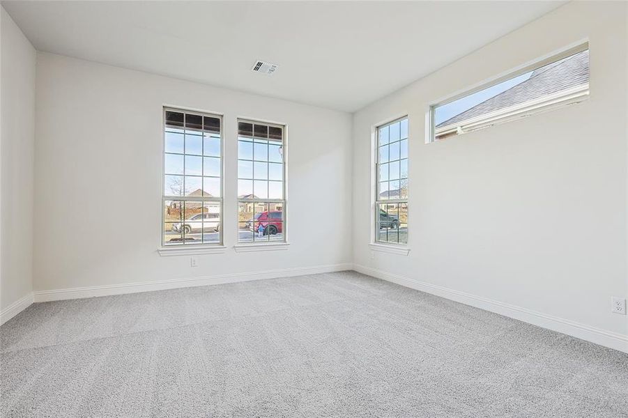 Spare room featuring carpet and plenty of natural light