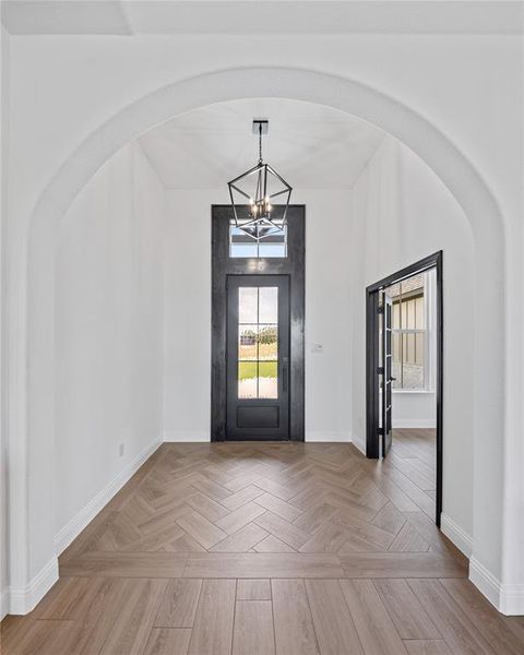 Entryway with a chandelier and arched walkways