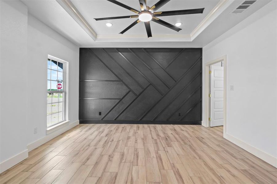 Unfurnished room with wood tiled floors, a decorative wall, a ceiling fan, a raised ceiling, and recessed lighting