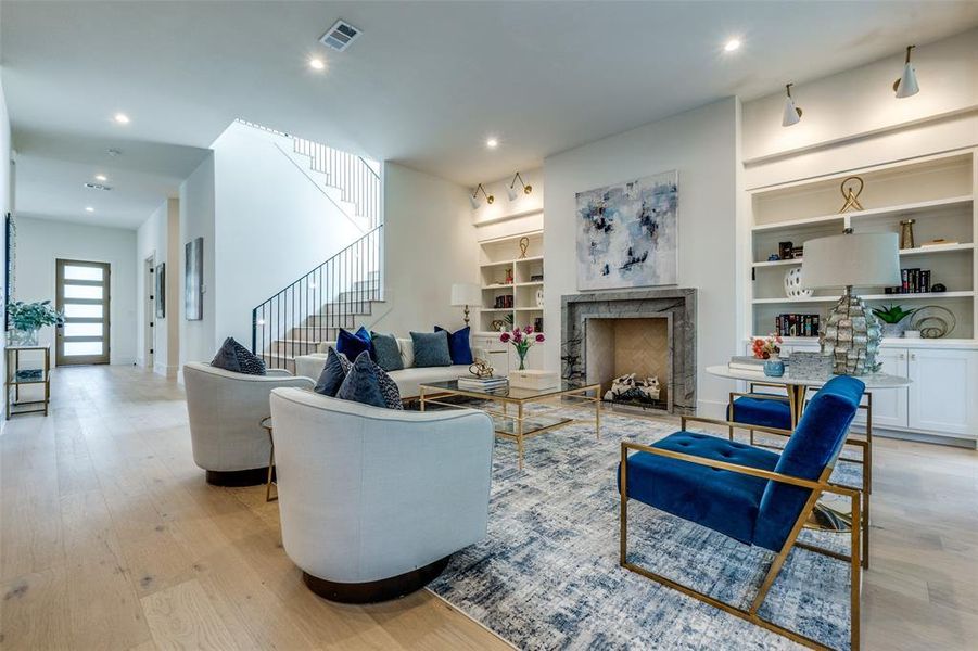 living room with custom built-ins, lighting and masonry fireplace