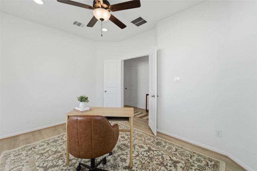 A quiet room featuring wood flooring and a classic ceiling fan, ideal for a home office. A quiet room featuring wood flooring and a classic ceiling fan, ideal for a home office.